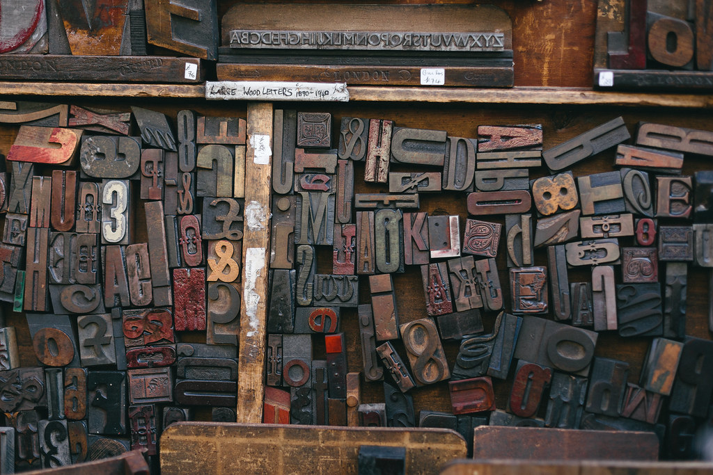 Assorted wood letter blocks for a printing press, stacked.